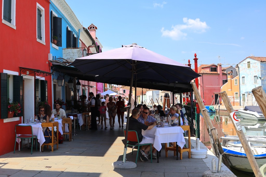 Canalside dining at Trattoria al Gatto Nero, Burano, Veneto, Italy